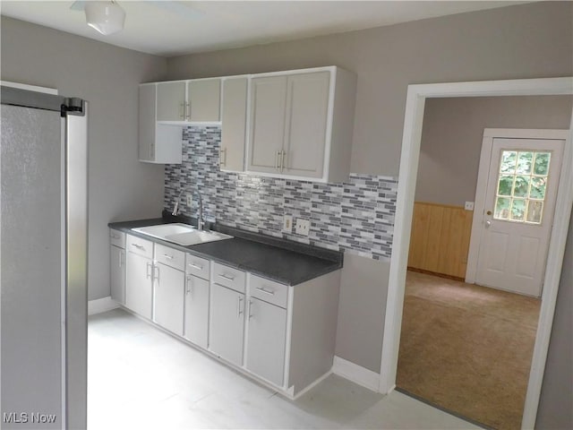 462 Monroe St, Conneaut, OH 44030 - kitchen featuring dark countertops, decorative backsplash, white cabinetry, and light colored carpet