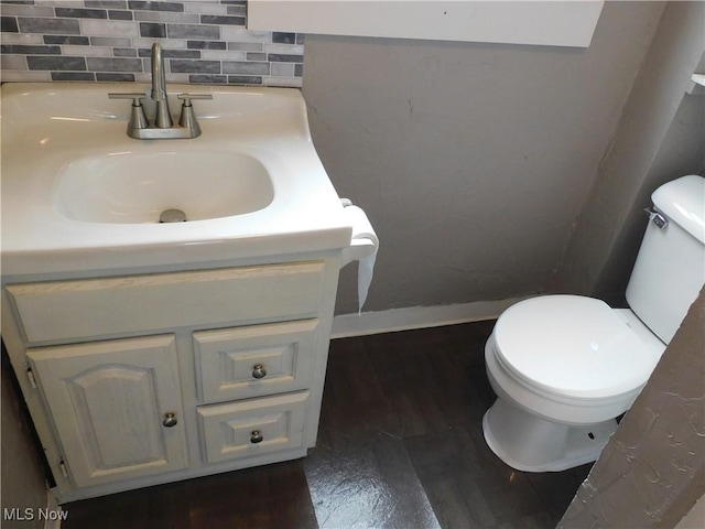 462 Monroe St, Conneaut, OH 44030 - half bath with vanity, wood finished floors, and decorative backsplash