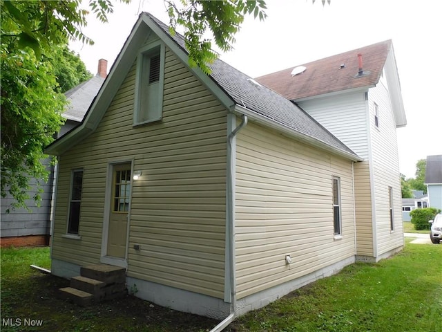 462 Monroe St, Conneaut, OH 44030 - view of side of property with entry steps, roof with shingles, and a yard