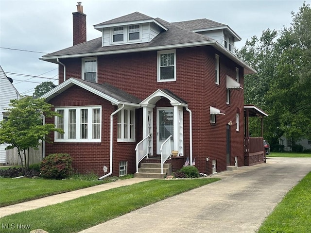1051 Oakwood Ave NE, Massillon, OH 44646 - american foursquare style home featuring entry steps, brick siding, a chimney, a shingled roof, and a front lawn