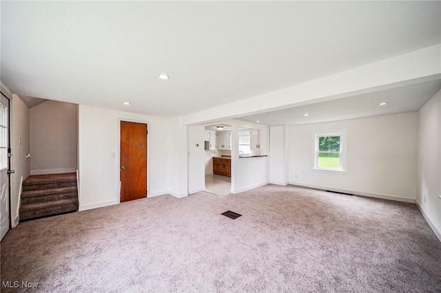 6136 Lake Rd W, Ashtabula, OH 44004 - unfurnished living room with light colored carpet, stairs, and recessed lighting
