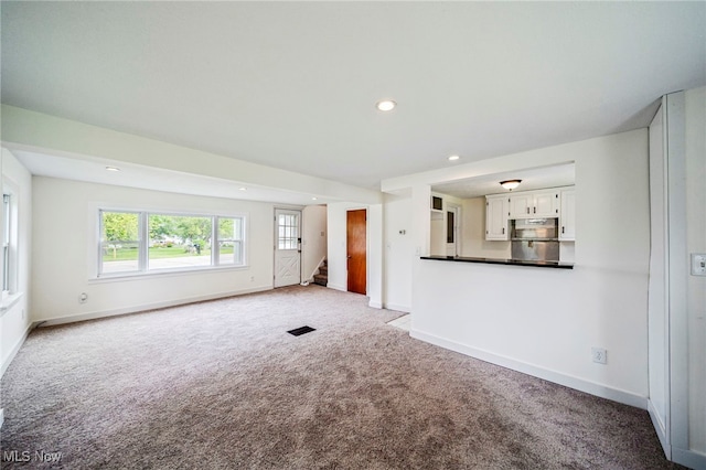 6136 Lake Rd W, Ashtabula, OH 44004 - unfurnished living room featuring stairway, carpet flooring, and recessed lighting