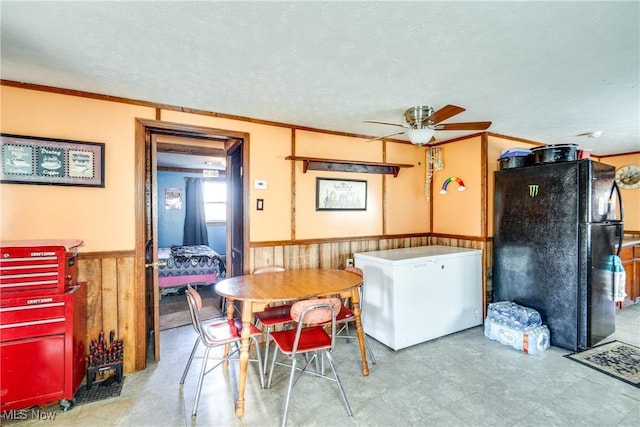 27901 State Route 30, Kensington, OH 44427 - dining room with ceiling fan, wainscoting, a textured ceiling, wood walls, and ornamental molding