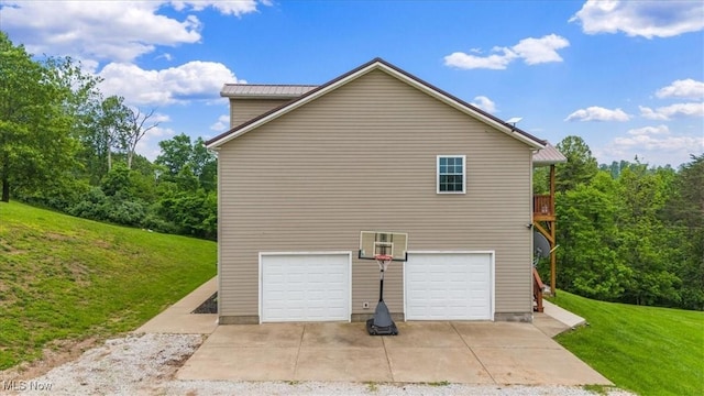 1448 Locust Ridge Rd, Washington, WV 26181 - view of side of property featuring a lawn, an attached garage, a metal roof, and driveway
