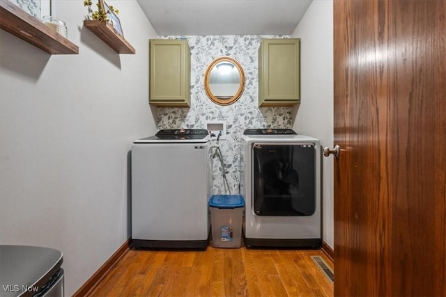 1448 Locust Ridge Rd, Washington, WV 26181 - laundry area with washing machine and clothes dryer, cabinet space, and light wood-style floors