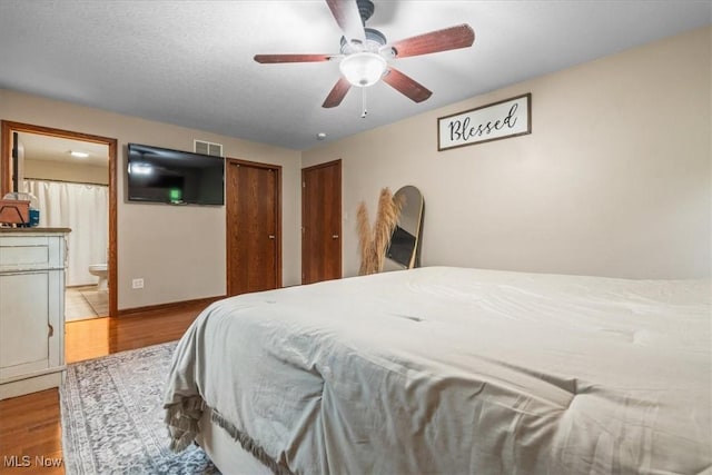 1448 Locust Ridge Rd, Washington, WV 26181 - bedroom featuring wood finished floors, ensuite bathroom, multiple closets, and a ceiling fan