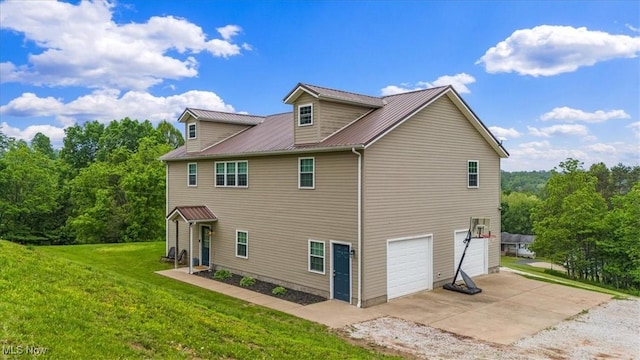1448 Locust Ridge Rd, Washington, WV 26181 - rear view of house featuring an attached garage, concrete driveway, a metal roof, and a lawn