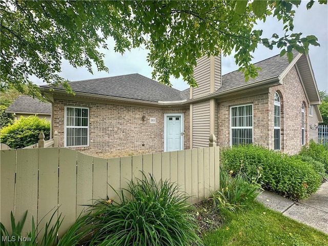 203 Willow Brook Dr NE, Warren, OH 44483 - view of front of house with brick siding, roof with shingles, and a chimney