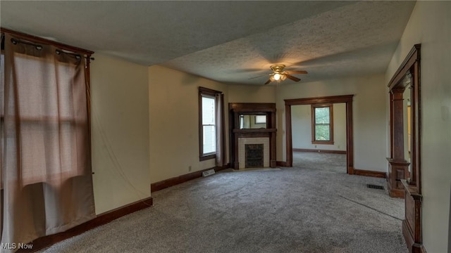 1515 Stewart Ave, Cambridge, OH 43725 - unfurnished living room featuring carpet, a fireplace with flush hearth, ceiling fan, and a textured ceiling