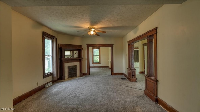 1515 Stewart Ave, Cambridge, OH 43725 - unfurnished living room featuring ceiling fan, carpet, a fireplace, and a textured ceiling