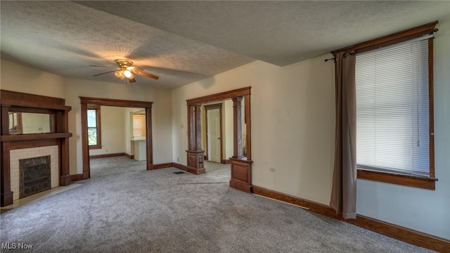 1515 Stewart Ave, Cambridge, OH 43725 - unfurnished living room featuring a textured ceiling, ceiling fan, carpet, and a tiled fireplace