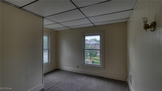 1515 Stewart Ave, Cambridge, OH 43725 - empty room featuring a drop ceiling, carpet, and wooden walls