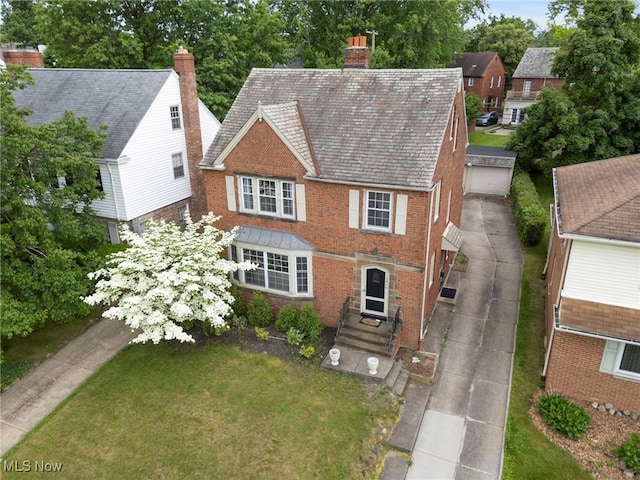 3846 Washington Blvd, University Heights, OH 44118 - view of front of home with brick siding, a chimney, a front yard, and a high end roof