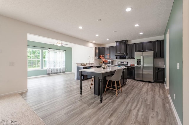 3478 Shadow Ledge Dr, Twinsburg, OH 44087 - kitchen with stainless steel appliances, light countertops, light wood-type flooring, a breakfast bar, and recessed lighting