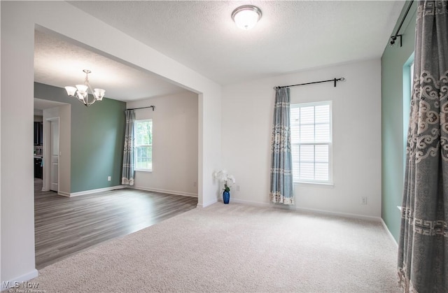 3478 Shadow Ledge Dr, Twinsburg, OH 44087 - unfurnished room featuring carpet, a chandelier, a textured ceiling, and wood finished floors