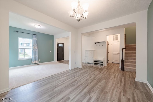 3478 Shadow Ledge Dr, Twinsburg, OH 44087 - unfurnished living room featuring light wood-style floors, a chandelier, and stairs