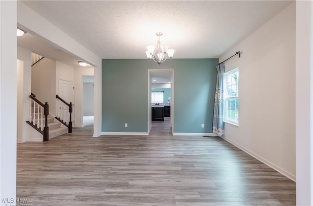 3478 Shadow Ledge Dr, Twinsburg, OH 44087 - spare room featuring healthy amount of natural light, a chandelier, wood finished floors, and stairs