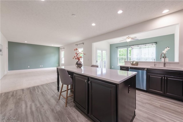 3478 Shadow Ledge Dr, Twinsburg, OH 44087 - kitchen with stainless steel dishwasher, a textured ceiling, open floor plan, a center island, and light countertops