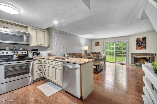2709 Graham Rd, Stow, OH 44224 - kitchen with stainless steel appliances, open floor plan, a textured ceiling, a peninsula, and cream cabinetry