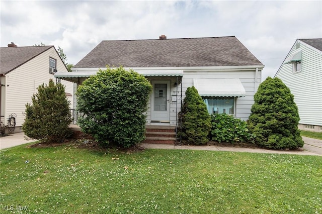 13112 Shady Oak Blvd, Garfield Heights, OH 44125 - view of front facade with a front lawn, roof with shingles, a chimney, and entry steps