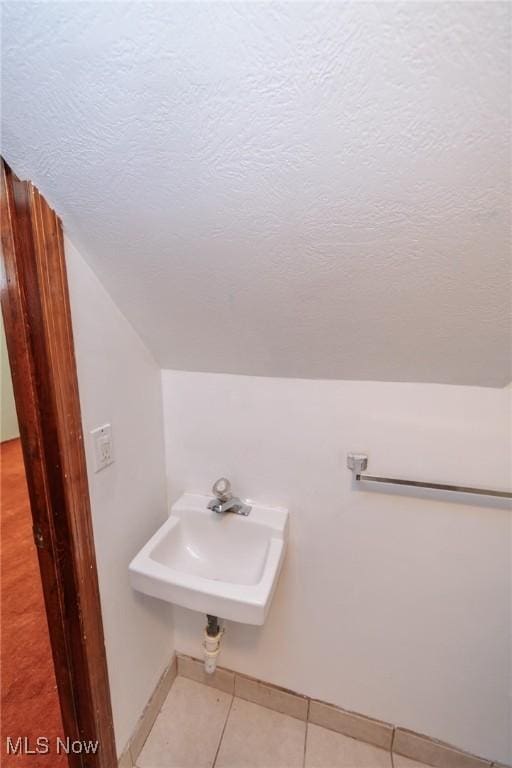 13112 Shady Oak Blvd, Garfield Heights, OH 44125 - bathroom featuring tile patterned flooring, vaulted ceiling, and a textured ceiling