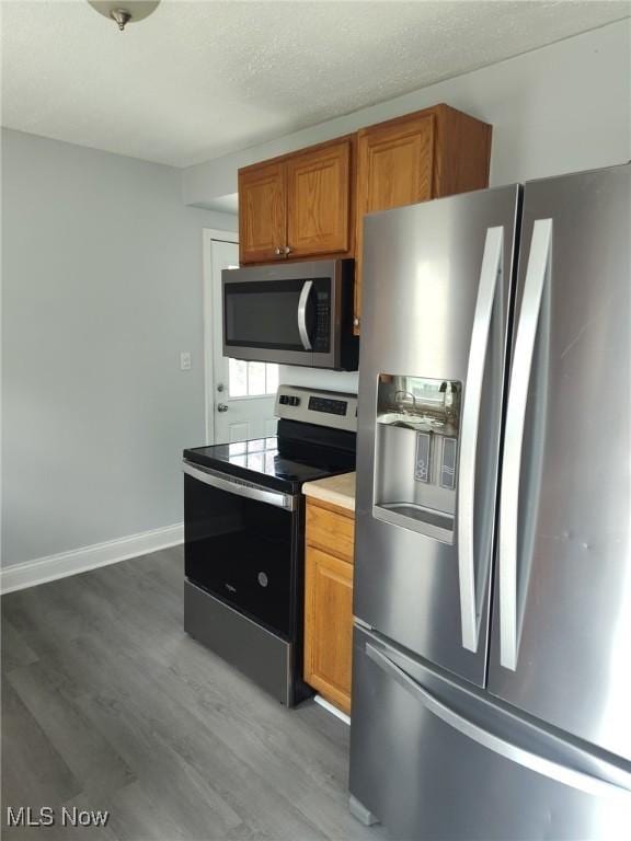 13112 Shady Oak Blvd, Garfield Heights, OH 44125 - kitchen featuring appliances with stainless steel finishes, light wood-style flooring, brown cabinetry, and light countertops