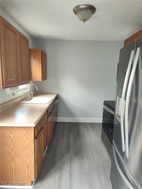 13112 Shady Oak Blvd, Garfield Heights, OH 44125 - kitchen with stainless steel appliances, wood finished floors, brown cabinets, and light countertops