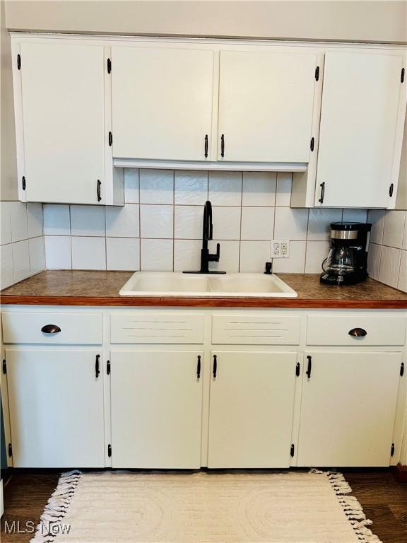 788 E Archwood Ave, Akron, OH 44306 - kitchen featuring decorative backsplash, white cabinetry, and dark wood-type flooring