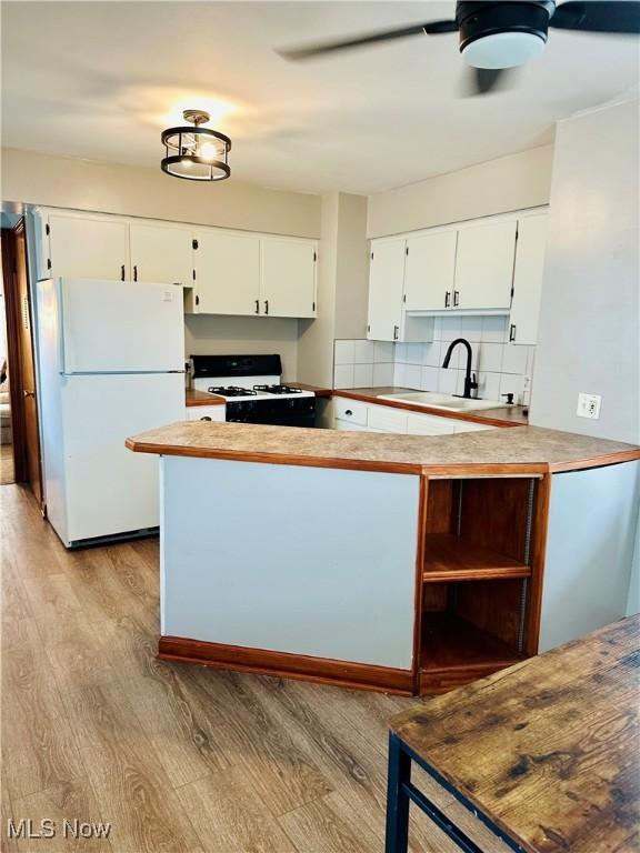788 E Archwood Ave, Akron, OH 44306 - kitchen featuring white appliances, light wood-type flooring, white cabinets, decorative backsplash, and open shelves