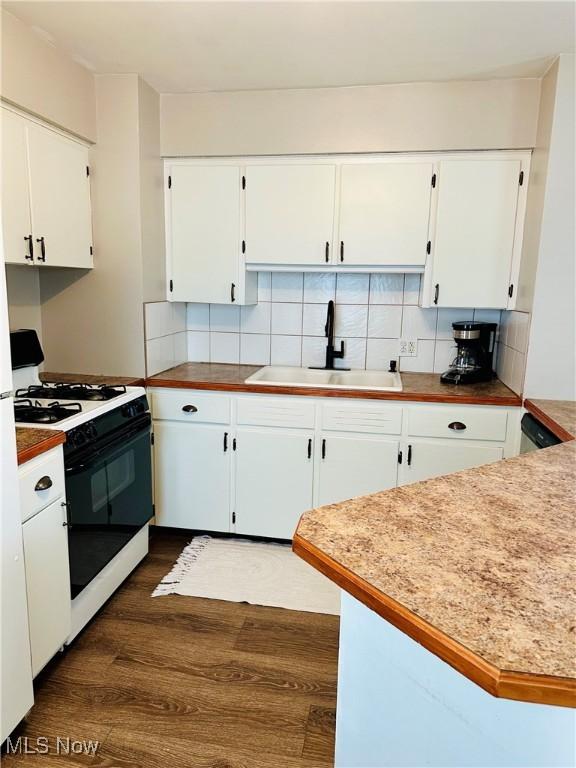 788 E Archwood Ave, Akron, OH 44306 - kitchen with range with gas cooktop, dark wood finished floors, white cabinets, and tasteful backsplash