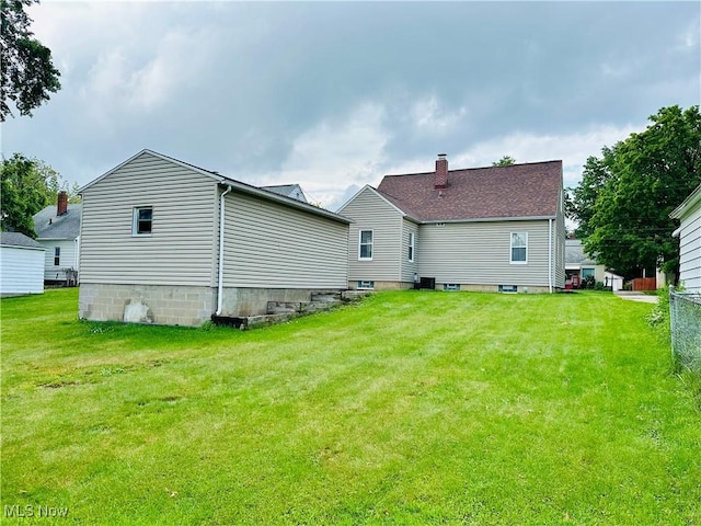 788 E Archwood Ave, Akron, OH 44306 - rear view of house featuring a yard and a chimney