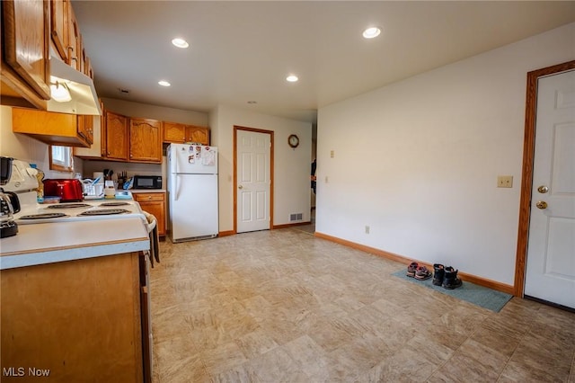 412 SW Weber Ave, Strasburg, OH 44680 - kitchen with freestanding refrigerator, brown cabinets, light countertops, light flooring, and recessed lighting