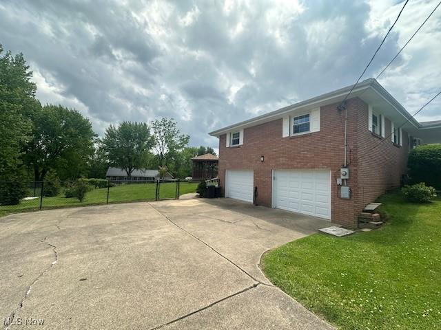 188 Court St, Follansbee, WV 26037 - view of property exterior featuring concrete driveway, a garage, and brick siding