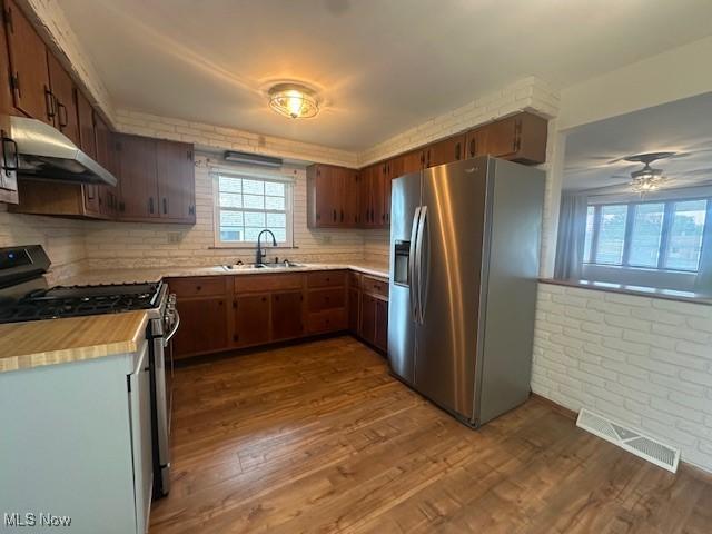 188 Court St, Follansbee, WV 26037 - kitchen featuring stainless steel fridge with ice dispenser, range with gas cooktop, under cabinet range hood, light countertops, and dark wood finished floors