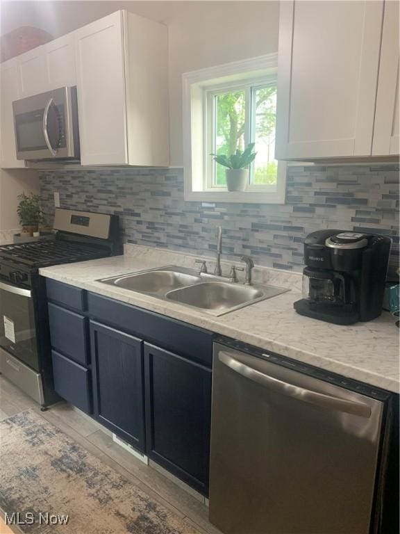 982 Day St, Conneaut, OH 44030 - kitchen featuring appliances with stainless steel finishes, white cabinetry, and backsplash