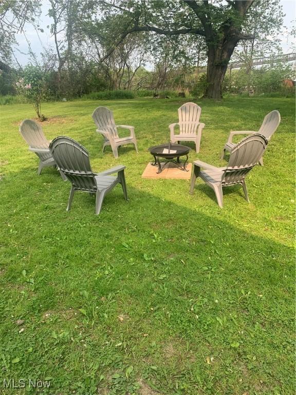 982 Day St, Conneaut, OH 44030 - view of grassy yard with an outdoor fire pit