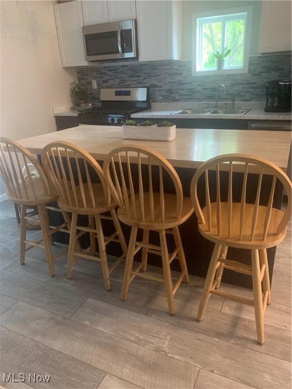 982 Day St, Conneaut, OH 44030 - kitchen with appliances with stainless steel finishes, tasteful backsplash, a center island, and a breakfast bar area