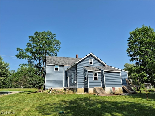 7810 Avon Lake Rd, Lodi, OH 44254 - back of house featuring a chimney, a yard, and roof with shingles