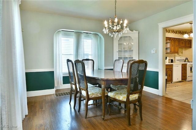 1774 Edgewood St NE, Warren, OH 44483 - dining area with a chandelier, arched walkways, and wood finished floors