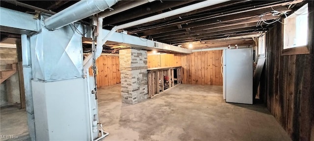 215 N 10th St, Cambridge, OH 43725 - unfinished basement with freestanding refrigerator, wood walls, and heating unit