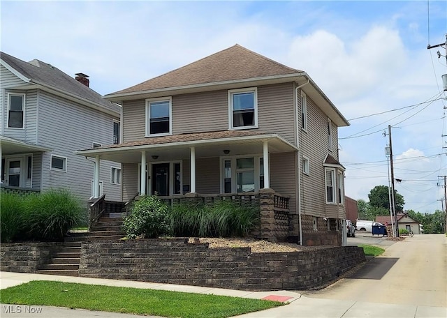 215 N 10th St, Cambridge, OH 43725 - american foursquare style home featuring a porch, stairway, and a shingled roof