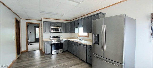 215 N 10th St, Cambridge, OH 43725 - kitchen with stainless steel appliances, gray cabinets, light wood-style flooring, light countertops, and crown molding