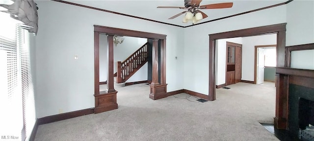 215 N 10th St, Cambridge, OH 43725 - empty room with carpet floors, ceiling fan, a fireplace with flush hearth, stairs, and crown molding