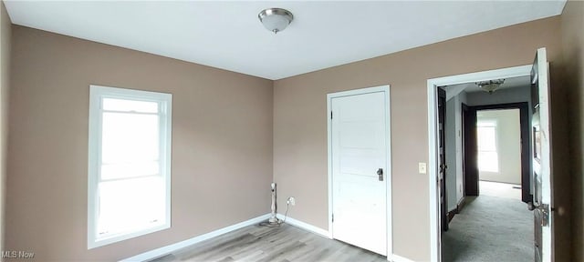 215 N 10th St, Cambridge, OH 43725 - unfurnished bedroom with multiple windows and light wood-type flooring