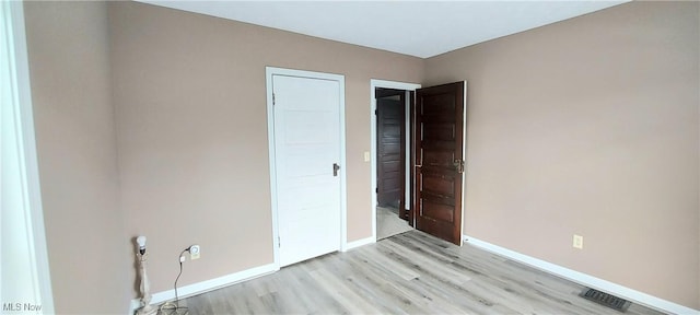 215 N 10th St, Cambridge, OH 43725 - unfurnished bedroom with light wood-style floors and baseboards