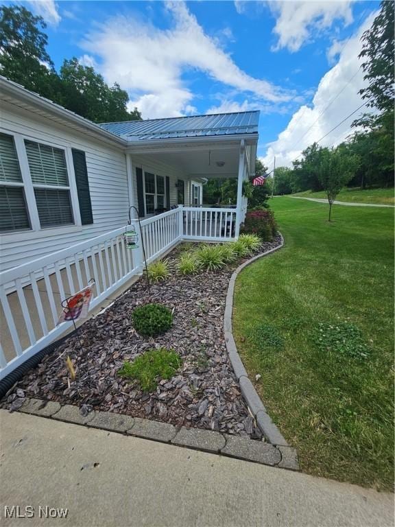 3925 N Wedgewood Dr, Mcconnelsville, OH 43756 - view of property exterior featuring a porch, a lawn, and a metal roof