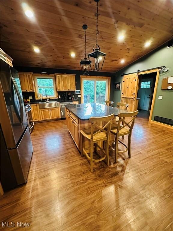 62063 Savage Rd, Cambridge, OH 43725 - kitchen with appliances with stainless steel finishes, a barn door, dark countertops, wood finished floors, and wooden ceiling