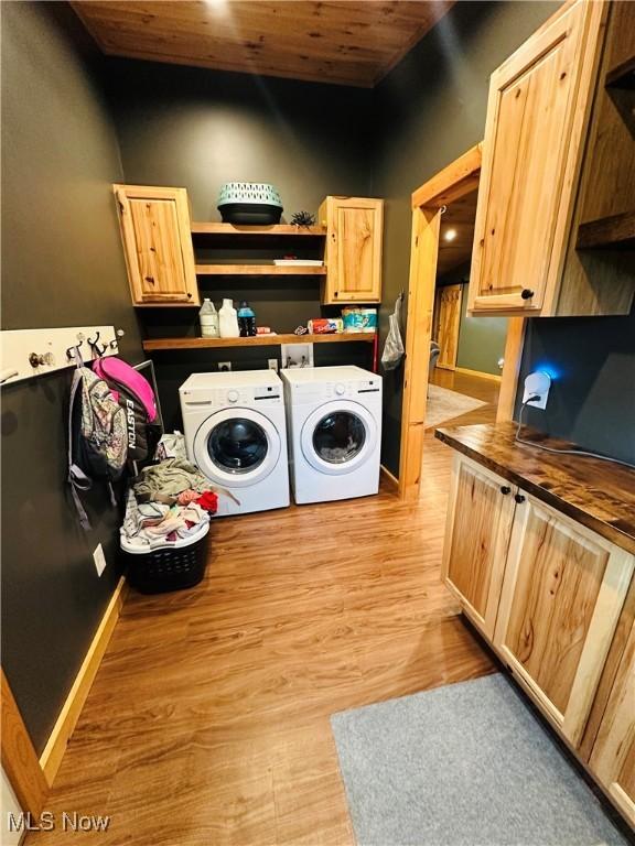 62063 Savage Rd, Cambridge, OH 43725 - laundry room featuring independent washer and dryer, cabinet space, wooden ceiling, and light wood finished floors