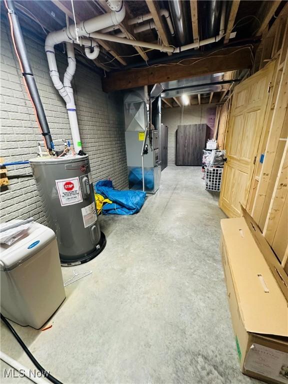 62063 Savage Rd, Cambridge, OH 43725 - unfinished basement featuring water heater, heating unit, and brick wall