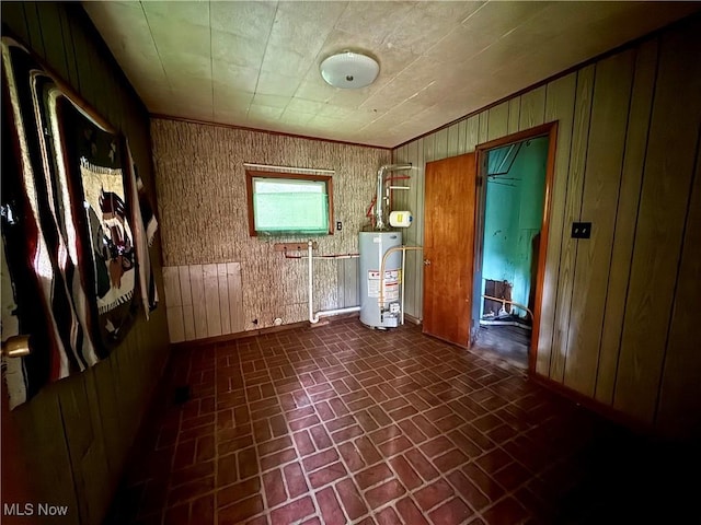 165 Killwell Run Rd, Marietta, OH 45750 - spare room featuring brick patterned flooring, gas water heater, and wood walls